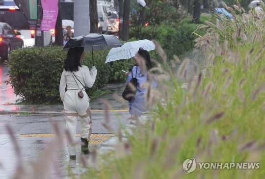 갑자기 소나기가 내린 지난 4일 오후 서울 종로구 광화문광장 인근에서 시민들이 비를 피하고 있다. 연합뉴스